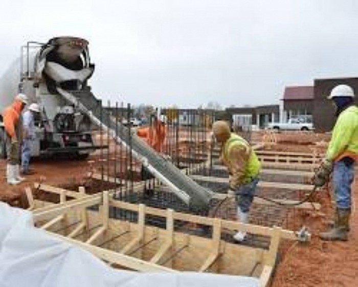 construction site with workers pouring concrete